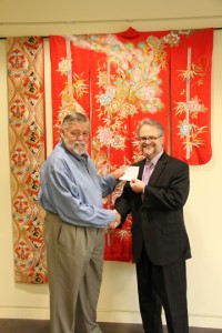 IU Southeast Professor Emeritus Jerry Wheat, left, presents IU Southeast Dean of the School of Business Jay White with the first funding for the recently established Jerry E. and Shelia R. Wheat International Study Scholarship outside the Center for Cultural Resources at IU Southeast.