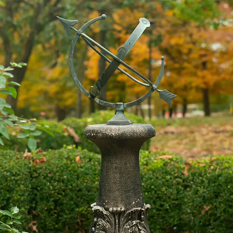 A sculpture of an arrow on IU Southeast's campus surrounded by fall leaves.