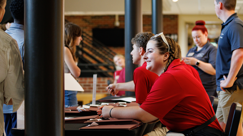A student worker assisting incoming students during an orientation event.