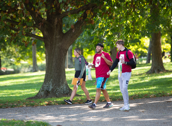 A trio of students walking along a sidewalk on campus.