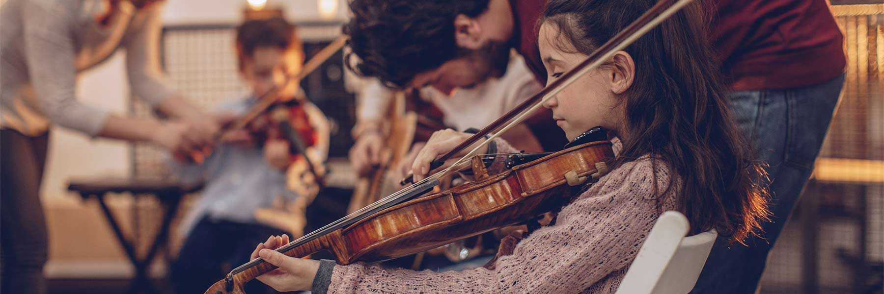 Young girl playing violin in a group class