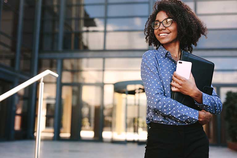 A person smiling in front of an office building
