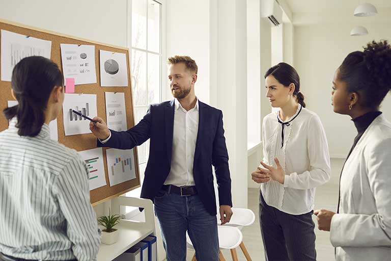 The presenter is showing business models in a small meeting