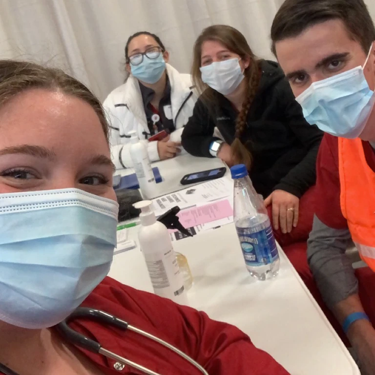 IU Southeast Nursing students wearing masks and taking a selfie at a table during their Remote Area Medical trip to Gray, TN