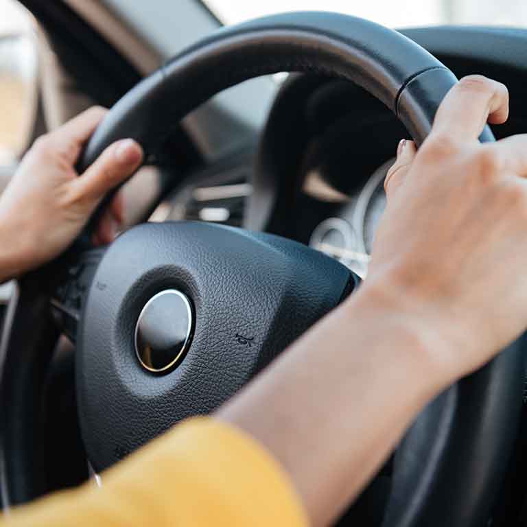Hands on a steering wheel of a car