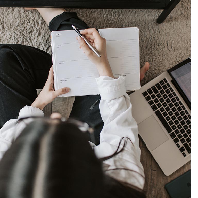 Female writing an appointment into planner. 