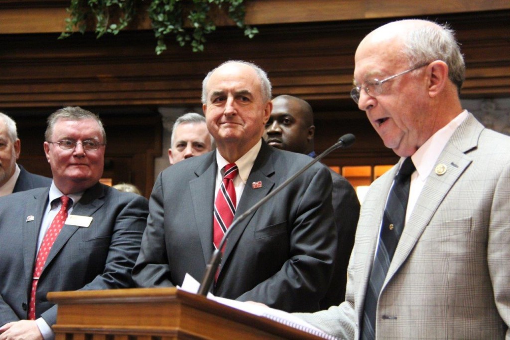 IU Southeast Chancellor Ray Wallace (left) and Indiana University President Michael A. McRobbie look on as Sen. Ron Grooms (R-Jeffersonville) presents the IU Southeast resolution to the senate floor.