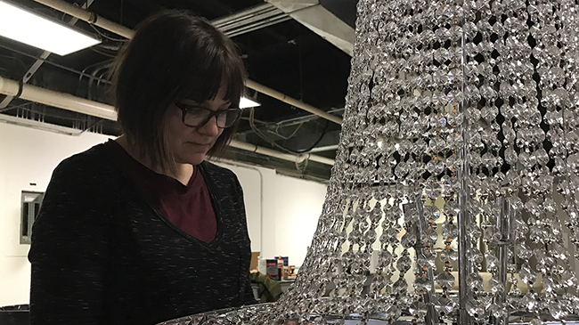 Tiffany Carbonneau assembles chandelier.
