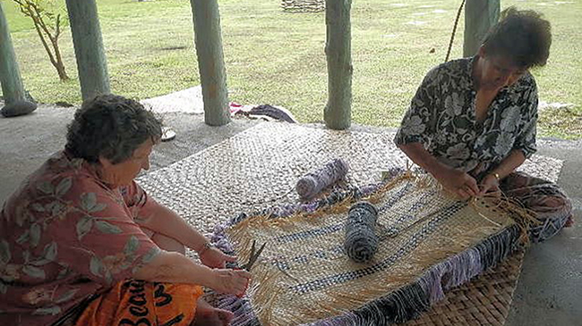 Allen works on a mat with her sister Elina, in Samoa.