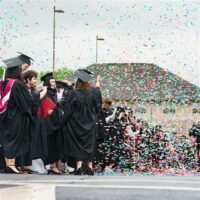 IU Southeast graduates celebrate commencement with confetti poppers.