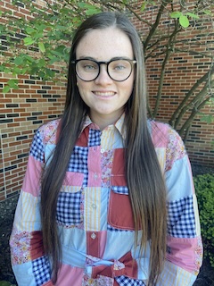 IU Southeast 2024 graduate Annmarie Freshour pictured on campus in a quilted shirt and glasses.