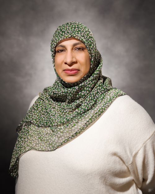 Dr. Sumreen Asim wearing a cream-colored top and green hijab